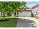 Charming home featuring a two-car garage, brick accents, and a beautifully landscaped front yard with a mature tree at 4136 Orchard Valley Ln, Indianapolis, IN 46235
