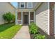Close up of front porch with brick facade, white pillars, and a well-maintained garden at 4136 Orchard Valley Ln, Indianapolis, IN 46235