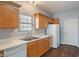 A well-lit kitchen featuring wood cabinets, a double sink, and appliances against the neutral wall paint at 4136 Orchard Valley Ln, Indianapolis, IN 46235