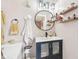 This bathroom features a modern vanity with a navy blue cabinet, round mirror, and industrial lighting fixtures at 4245 Guilford Ave, Indianapolis, IN 46205