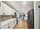 Open kitchen with white cabinets, stainless appliances, and gray subway tile backsplash at 4245 Guilford Ave, Indianapolis, IN 46205