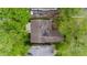 Birds-eye view of a home with a dark brown roof surrounded by mature green trees, and other houses at 425 S Oakland Ave, Indianapolis, IN 46201