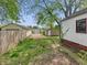 Exterior view of the home's backyard with grass, a fence and detached garages at 425 S Oakland Ave, Indianapolis, IN 46201