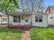 Quaint single-Gathering home showcasing a classic front porch and a tidy lawn with mature trees in the background at 425 S Oakland Ave, Indianapolis, IN 46201