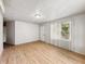 Spacious living room with light hardwood flooring, a large window with blinds, and neutral wall colors at 425 S Oakland Ave, Indianapolis, IN 46201
