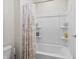 Well-lit bathroom featuring a shower and tub with a patterned shower curtain and built-in shelves at 4629 Rainwater Ln, Whitestown, IN 46075