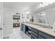 Bright bathroom featuring double sinks and entry to bedroom with bed and book shelving at 4629 Rainwater Ln, Whitestown, IN 46075