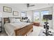 Bright bedroom with a wooden bed frame, neutral bedding, a ceiling fan, and natural light from two windows at 4629 Rainwater Ln, Whitestown, IN 46075