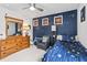 Charming bedroom with blue galaxy wallpaper, light walls, an armchair, and a wooden dresser with mirror at 4629 Rainwater Ln, Whitestown, IN 46075