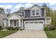 Traditional home features a two-car garage, blue and gray siding, a manicured lawn, and a classic design at 4629 Rainwater Ln, Whitestown, IN 46075