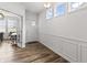 Bright entryway with wood floors, white wainscoting, and a glimpse into a bright, airy office at 4629 Rainwater Ln, Whitestown, IN 46075