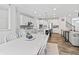 Open kitchen with white cabinets, modern appliances, island with seating, flows into dining and living areas at 4629 Rainwater Ln, Whitestown, IN 46075