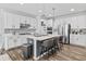 Bright kitchen featuring white cabinets, stainless appliances, gray backsplash, and island with seating at 4629 Rainwater Ln, Whitestown, IN 46075