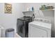 Functional laundry room with modern washer and dryer, shelving and Indy decor at 4629 Rainwater Ln, Whitestown, IN 46075