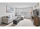 Cozy living room featuring a sectional couch, stylish ottoman, and a wall-mounted TV at 4629 Rainwater Ln, Whitestown, IN 46075