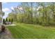 Back patio featuring a table and chairs, grill, and view of the lush lawn and surrounding trees at 4629 Rainwater Ln, Whitestown, IN 46075
