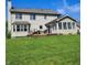 Expansive backyard with green grass, a deck, and a sunroom addition at 4719 Arabian Run, Indianapolis, IN 46228