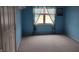 This bedroom features light blue painted walls, a gray carpet, and a window at 4719 Arabian Run, Indianapolis, IN 46228
