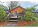 Back deck and orange house featuring a grill, flowers, an umbrella, a privacy fence, and mulch at 4810 Winthrop Ave, Indianapolis, IN 46205