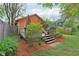 Back deck and orange house featuring a grill, flowers, an umbrella, a privacy fence, and mulch at 4810 Winthrop Ave, Indianapolis, IN 46205
