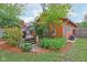 Landscaped backyard featuring a stone walkway, wooden deck, lush greenery, and colorful flowers at 4810 Winthrop Ave, Indianapolis, IN 46205
