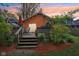 A cozy backyard with a wooden deck, outdoor seating, a grill, and lush landscaping at 4810 Winthrop Ave, Indianapolis, IN 46205