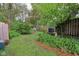 Lush backyard featuring grass, mulch path and mature trees, providing a peaceful and private setting at 4810 Winthrop Ave, Indianapolis, IN 46205
