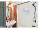 Charming bathroom featuring a vintage-style sink, decorative mirror, and a stylish shower with patterned wall at 4810 Winthrop Ave, Indianapolis, IN 46205