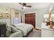 Bedroom with a ceiling fan and green walls, featuring closet with dark wood doors and a dresser at 4810 Winthrop Ave, Indianapolis, IN 46205