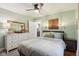 Bedroom with a white dresser, night stand, ceiling fan, neutral walls, and view into the kitchen at 4810 Winthrop Ave, Indianapolis, IN 46205