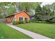 Charming orange single-story home with a well-maintained lawn and lush green trees at 4810 Winthrop Ave, Indianapolis, IN 46205