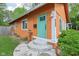 Charming orange single-story home with a vibrant blue door and manicured landscaping at 4810 Winthrop Ave, Indianapolis, IN 46205