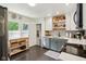 Well-lit kitchen with modern appliances, gray cabinets, open shelving, and a stylish rolling wood island at 4810 Winthrop Ave, Indianapolis, IN 46205
