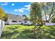 Well-kept backyard featuring a manicured lawn, mature tree, and a white fence at 51 Wilson Dr, Carmel, IN 46032
