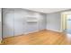 Bedroom featuring pristine hardwood floors, large closet doors, and neutral grey walls at 51 Wilson Dr, Carmel, IN 46032