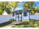 Charming shed with blue trim, surrounded by lush landscaping and a white fence at 51 Wilson Dr, Carmel, IN 46032