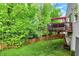A spacious backyard featuring a wooden deck, lush green grass, and a charming wooden fence at 5348 Pelham Way, Indianapolis, IN 46216