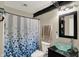 Bathroom featuring shower with blue curtain, toilet, and black countertop with glass sink at 5348 Pelham Way, Indianapolis, IN 46216