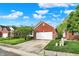 Brick home featuring a well-manicured lawn and a two-car garage with a concrete driveway at 5348 Pelham Way, Indianapolis, IN 46216