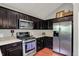 Well-lit kitchen features dark cabinetry, stainless steel appliances, and light countertops at 5348 Pelham Way, Indianapolis, IN 46216