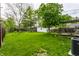 Expansive backyard with lush green grass, trees, and a back deck, offering plenty of space for outdoor activities at 5643 Rosslyn Ave, Indianapolis, IN 46220