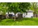 Beautiful backyard with deck, patio furniture, lush greenery, and a shade tree, creating a serene outdoor oasis at 5643 Rosslyn Ave, Indianapolis, IN 46220