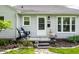 Charming front porch with chairs, planters, and a welcoming entrance, enhancing the curb appeal of the home at 5643 Rosslyn Ave, Indianapolis, IN 46220