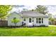 Charming single story home with a manicured lawn, flowering tree, and welcoming front porch at 5643 Rosslyn Ave, Indianapolis, IN 46220