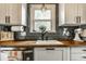 Close-up of kitchen sink with dark subway tile backsplash, wood counters and a window at 5643 Rosslyn Ave, Indianapolis, IN 46220