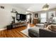 Spacious living room featuring hardwood floors, comfortable sofa, and a large flat-screen TV at 5643 Rosslyn Ave, Indianapolis, IN 46220