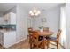 Cozy dining area with a round table, four chairs, and a stylish chandelier, adjacent to the kitchen at 5744 Spruce Knoll Ct, Indianapolis, IN 46220