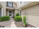 Close-up of the home's exterior, showing the siding, trim, and front entrance surrounded by lush greenery at 5744 Spruce Knoll Ct, Indianapolis, IN 46220