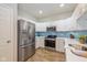 Modern kitchen with stainless steel appliances, white cabinets, and eye-catching backsplash at 5744 Spruce Knoll Ct, Indianapolis, IN 46220