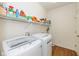 Bright laundry room with modern washer and dryer, plus shelving for organizing supplies at 5744 Spruce Knoll Ct, Indianapolis, IN 46220